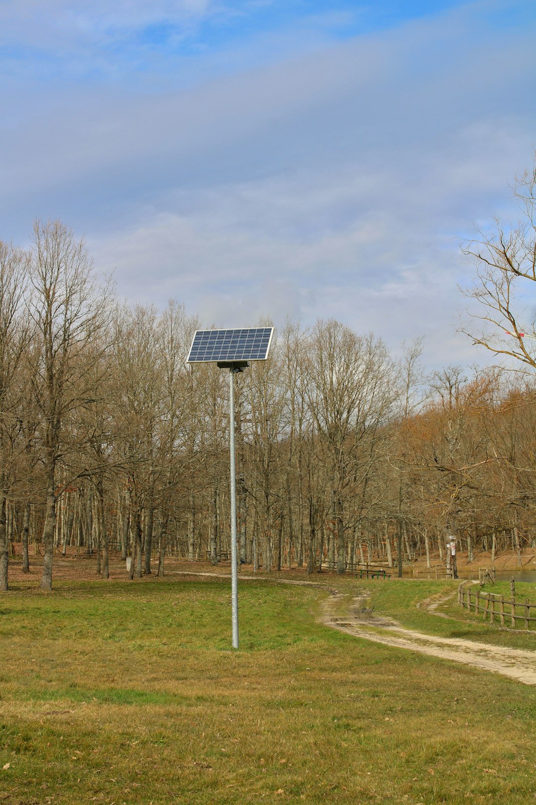solar-panel-stands-in-a-grassy-field-near-trees-pxhrr1q3my4